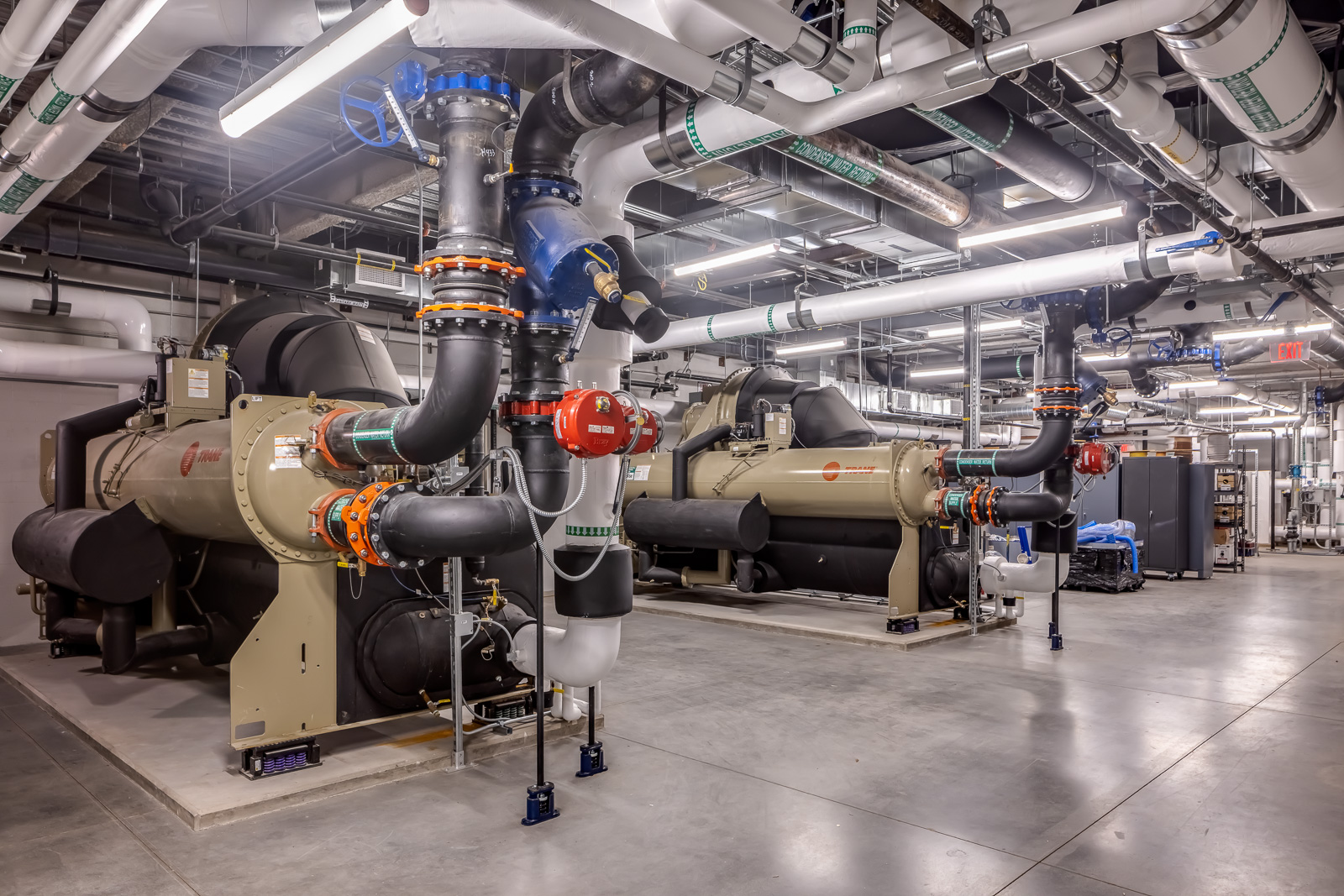 Central industrial de climatização com chillers e tubulações